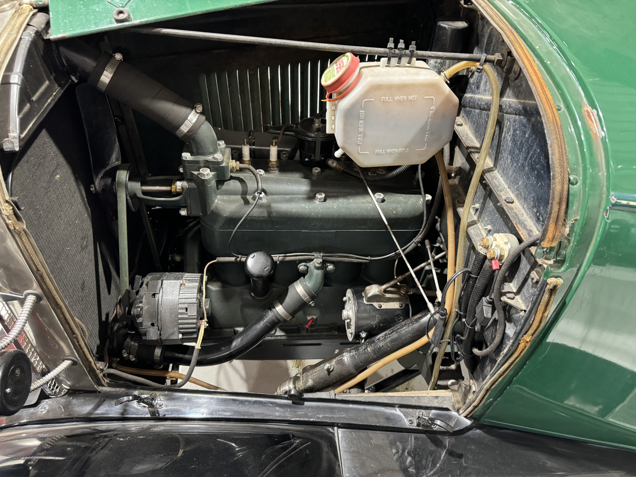 Drivers side of engine showing coolant overflow, 6 volt pos ground alternator